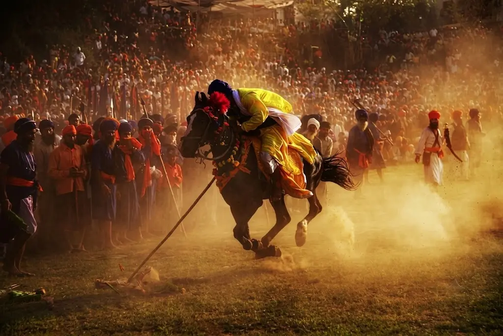 A rider strikes the peg at sunset in front of a packed crowd